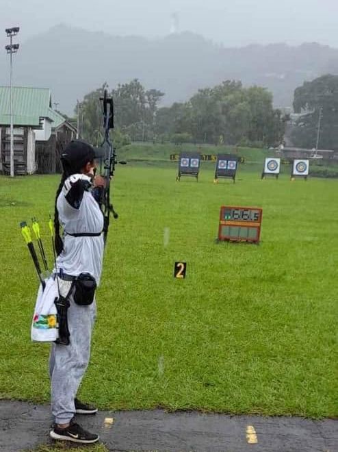 Archer du club tirant sous la pluie, face aux cibles et au compte à rebours du stade Pater.